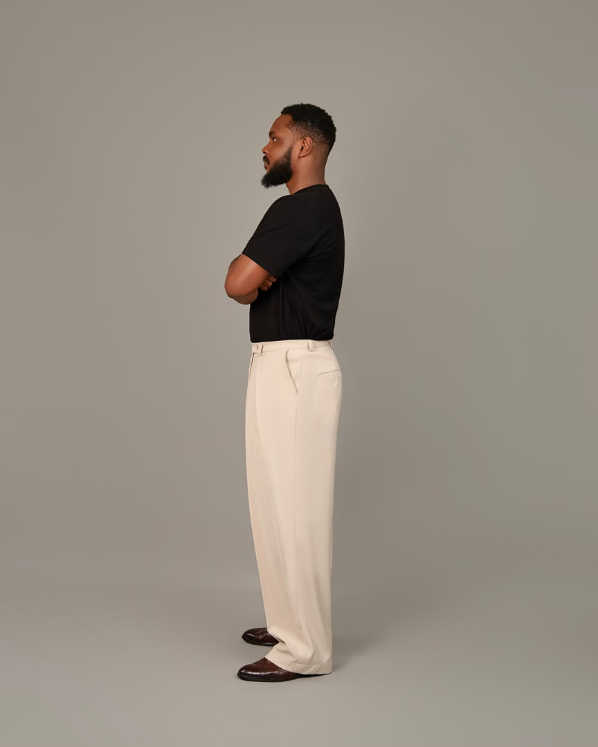 Model wearing the Melvado ivory pleat trouser in profile